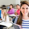 Female college student in a classroom holding a notebook